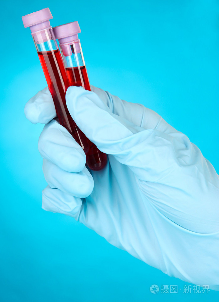 用在手上的血试管蓝色的背景