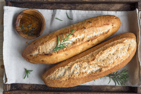 新鲜的自制面包与迷迭香和特级初榨橄榄油在质朴的木盒, 顶部视图。酵母迷你面包