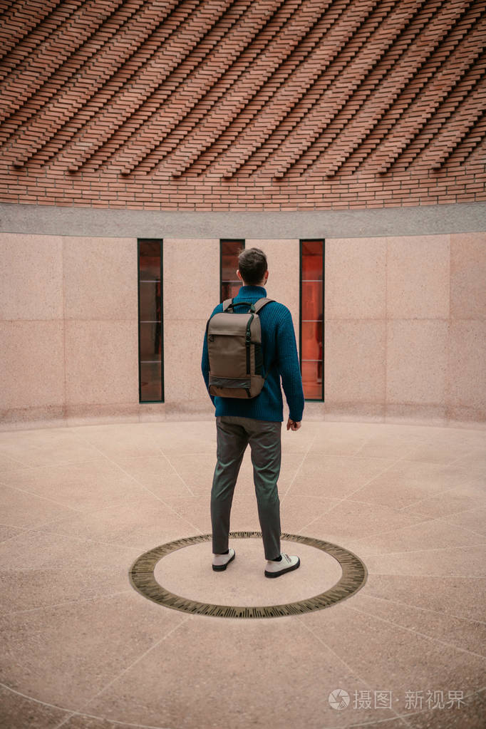 男人背着背包在城里
