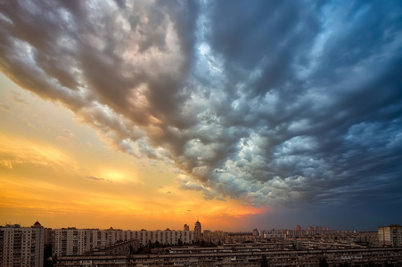 日落乌云笼罩的城市景观的背景