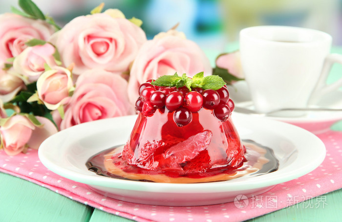 美味果冻甜点与新鲜浆果在明亮的背景上