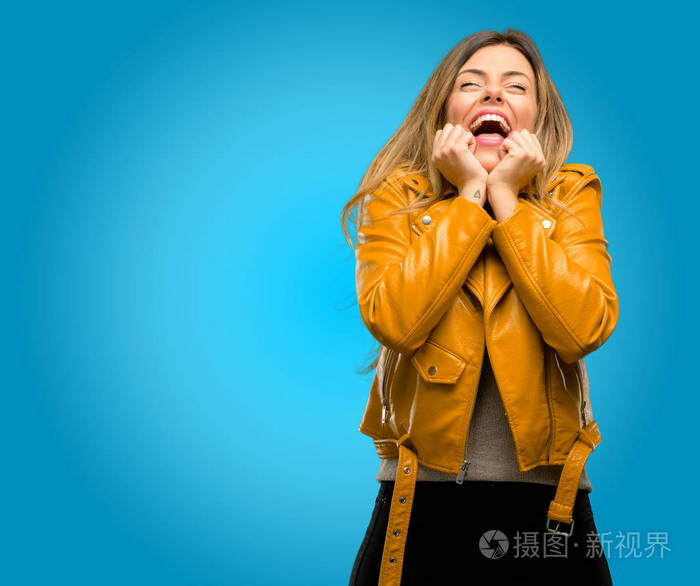 美丽的年轻女子高兴和惊喜欢呼表达哇手势, 蓝色背景