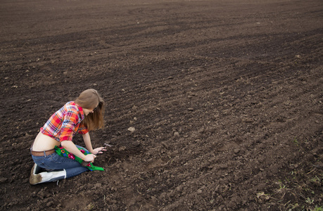 女人耙在耕地黑色的土地上