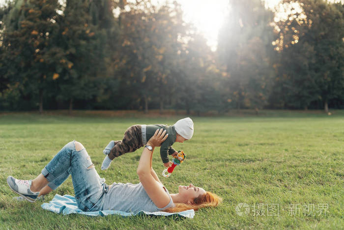 在大自然的毯子上休息的快乐母亲养育孩子