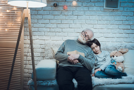 祖父和孙子睡在家里的沙发上
