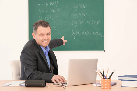 男教师在课堂上使用笔记本电脑