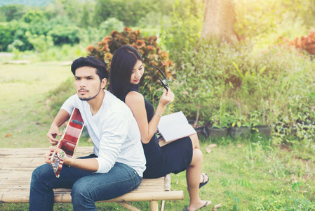 年轻迷人的情侣在爱演奏声学吉他在标准