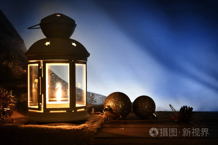在黑暗中的木桌上点燃灯笼和圣诞装饰的构图.水平组合