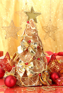 干柠檬与装潢，在黄色背景上的漂亮的圣诞树
