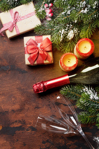 圣诞礼品盒, 蜡烛, 香槟和冷杉树枝覆盖在木质的背景雪。顶部查看圣诞背景与空间为您的问候