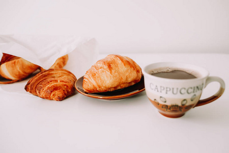 白色背景早餐杯热咖啡和羊角面包
