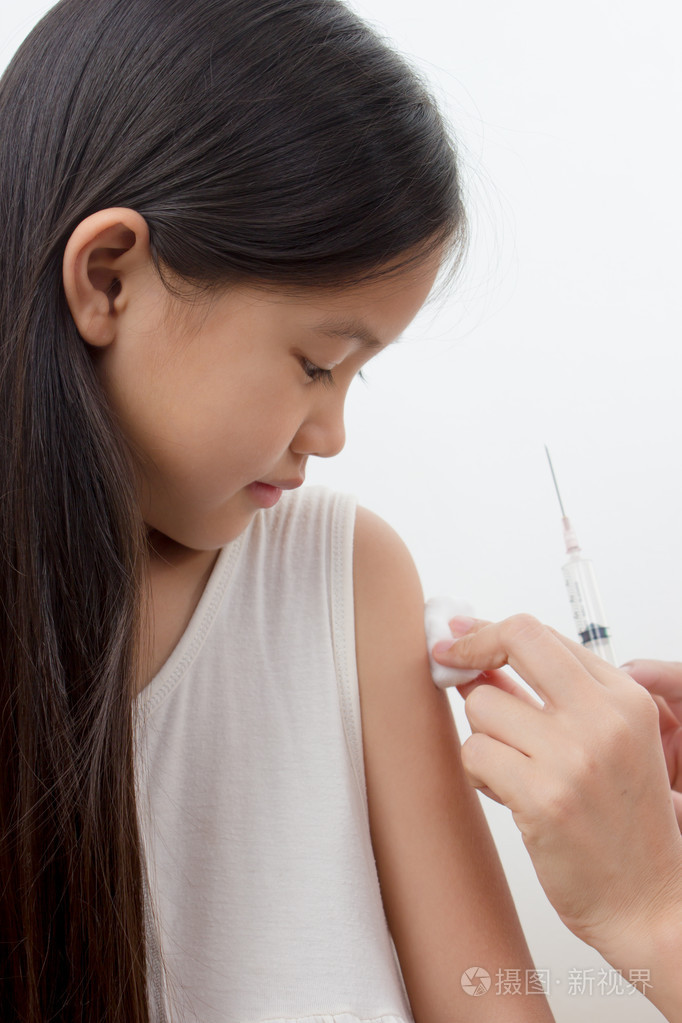 医生给注射液对亚洲女孩的手臂