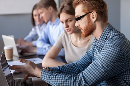 专注认真的同事一起讨论电脑照片