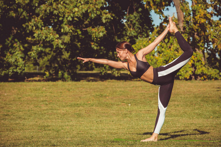 赤脚女子在公园练瑜珈, 罗盘 dhanurasana 姿势