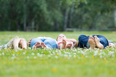 幸福的年轻家庭，躺在草地上