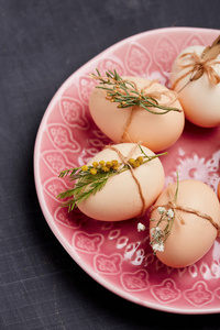 新鲜鸡肉和鹌鹑蛋在粉红色的盘子里。顶部视图。健康食品与有机农业概念
