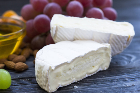 奶酪切割与无花果, 坚果, 蜂蜜, 葡萄在一个黑暗的乡村木板背景。顶部视图
