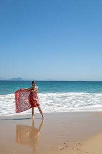 漂亮女人与围巾和太阳镜上海滩
