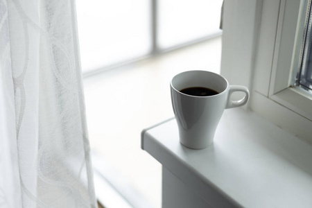 窗台上的一杯咖啡。大窗户。斯堪的纳维亚风格。复制空间