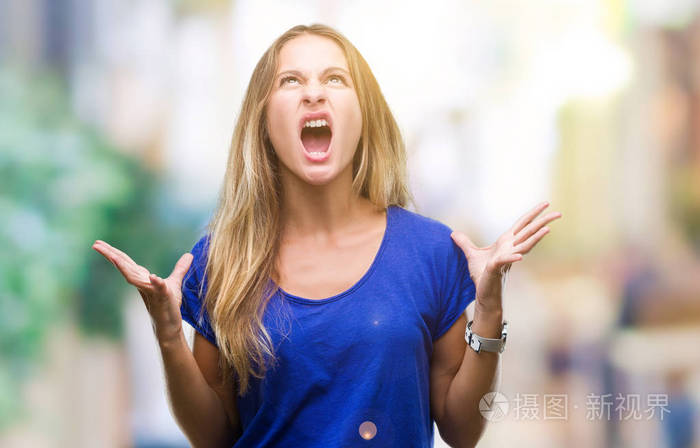 年轻美丽的金发女人在孤立的背景下疯狂和疯狂的呼喊和挑衅的表达和