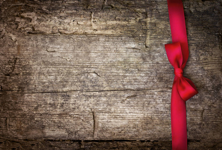 特写镜头看到圣诞节红色丝带, 装饰在复古风格的木制背景