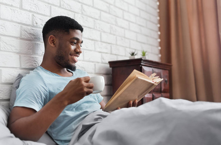 黑衣人在床上喝咖啡看书