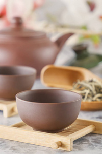 在特殊的木杯杯的棕色陶瓷茶壶为传统的亚洲茶道准备