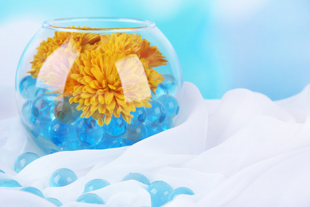 美丽的鲜花在水凝胶在明亮的背景上桌上的花瓶