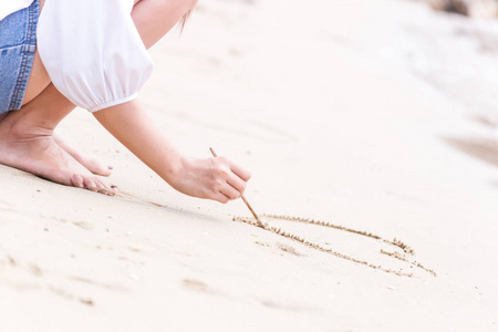 在沙滩上写着沙子的女人
