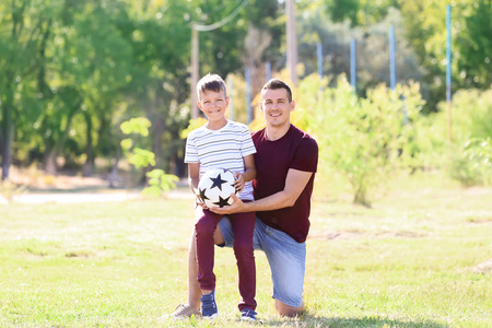 小男孩踢球小男孩和他的爸爸在户外踢球照片