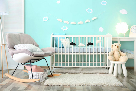 现代婴儿房室内配有婴儿床和摇椅