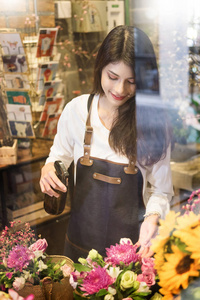 年轻女性企业主花店在 f 前面做花束