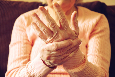 接近成熟的女人的手。医疗保健给, 疗养院。父母对祖母的爱。老年相关疾病