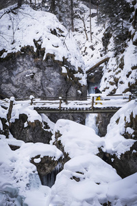 年轻女子徒步穿越雪山峡谷 Baerenschuetzklamm 冰冻瀑布