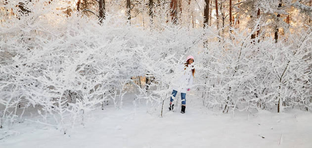 女孩在冬季森林与雪覆盖树枝的树木。仙女美人