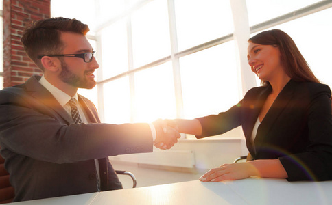 女商人和 b 之间的特写友好会议握手办公室里的同事之间的友好握手