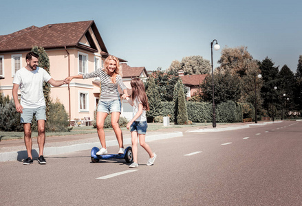 满意的漂亮女人骑在自平衡滑板车有乐趣