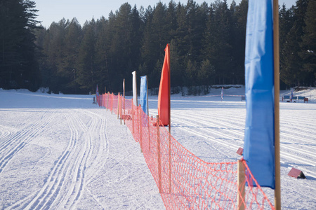雪炮在一个阳光明媚的日子, 在滑雪胜地, 在空围栏轨道滑雪者