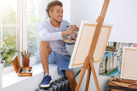 年轻的非洲裔美国艺术家在家里画图片
