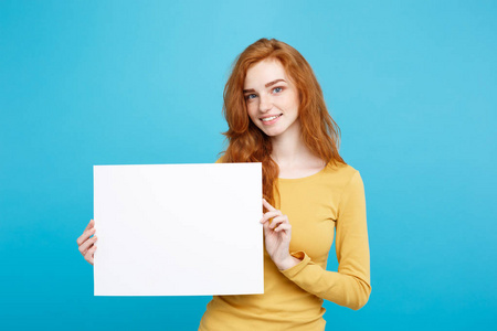 经营理念特写肖像年轻美丽诱人 redhair 女孩微笑着空白的迹象。蓝色柔和的背景