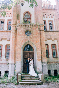 新婚夫妇摆在老惊人的城堡附近