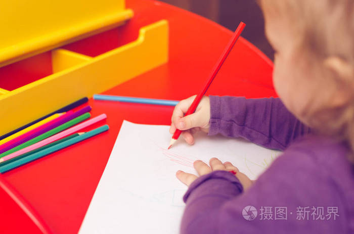 在红桌上, 孩子们用彩色铅笔和一张白纸