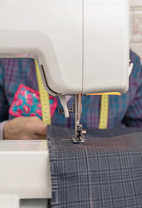 缝纫机针和背景的女裁缝