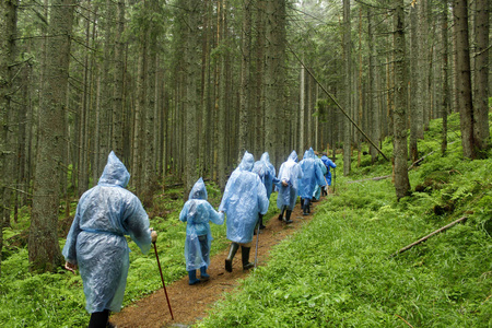 徒步旅行者在雨中爬上山