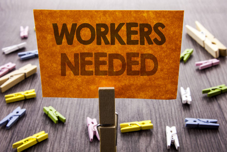 手写的文本符号显示需要的工人。寻找职业资源的商业理念员工失业问题在木质背景上的粘纸条上写着