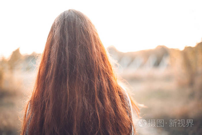 模糊背景下红发女人的背影