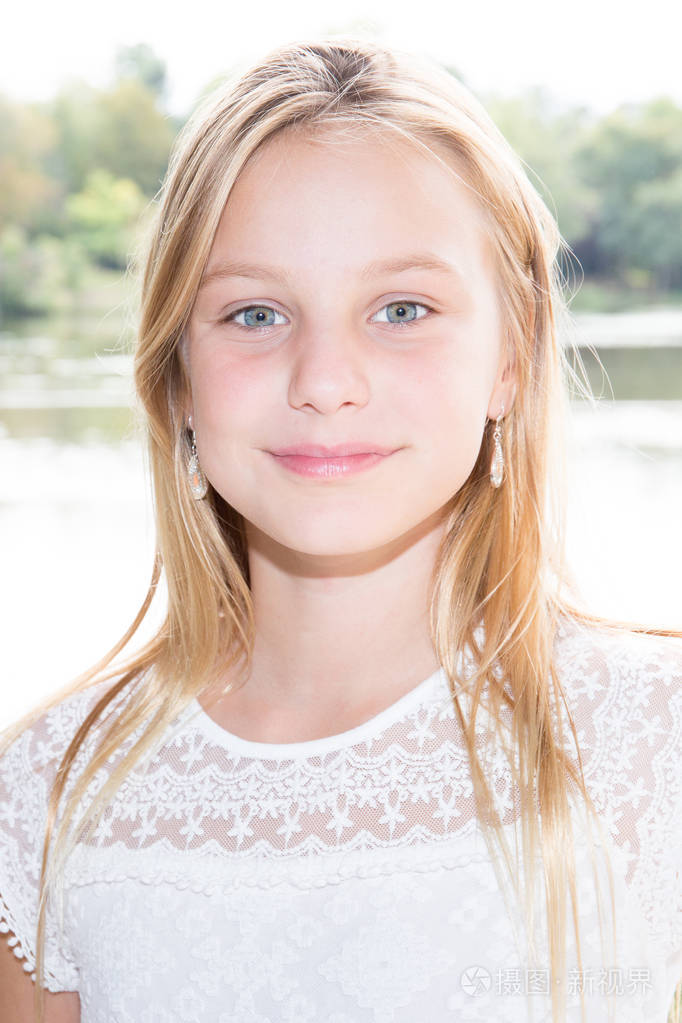 可爱的小女孩在户外与金色的头发在海岸湖