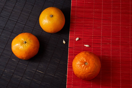 黑橘搭配柑桔, clementines, 柑橘类水果在样式黑和红色背景与拷贝