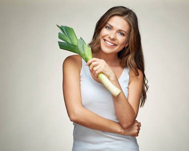 快乐的微笑的妇女举行绿色韭菜, 健康食物概念