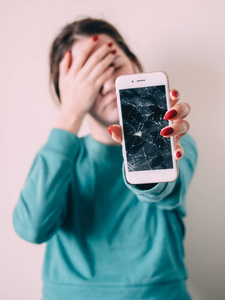 破碎的玻璃屏幕智能手机在不开心的女孩手, 白色背景